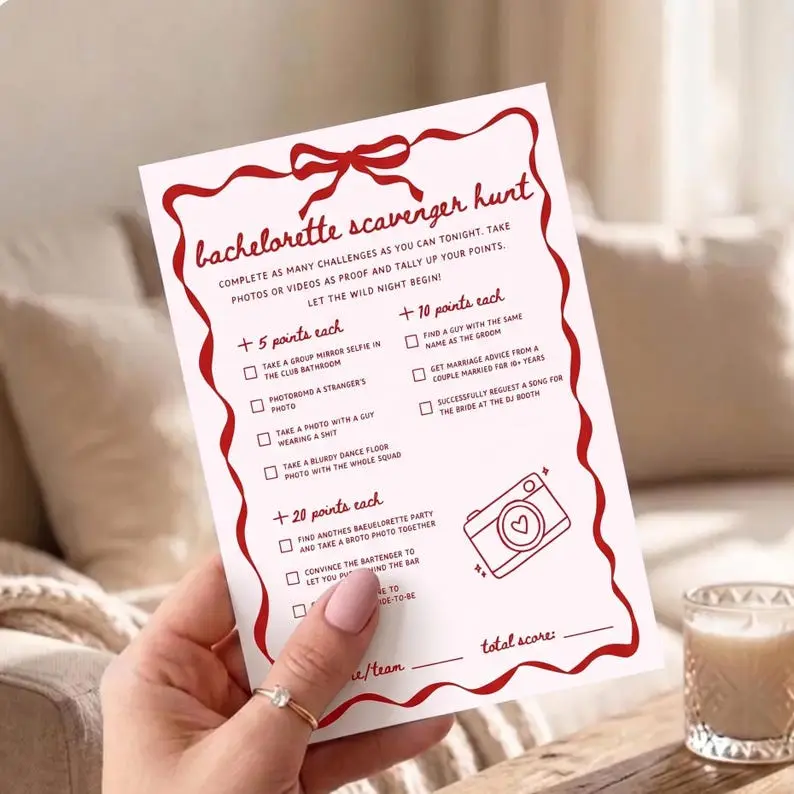 Bachelorette Scavenger Hunt card in blush with a red wavy ribbon border and bow, listing challenges grouped into five, ten and twenty point tiers beside a drawn camera with a heart